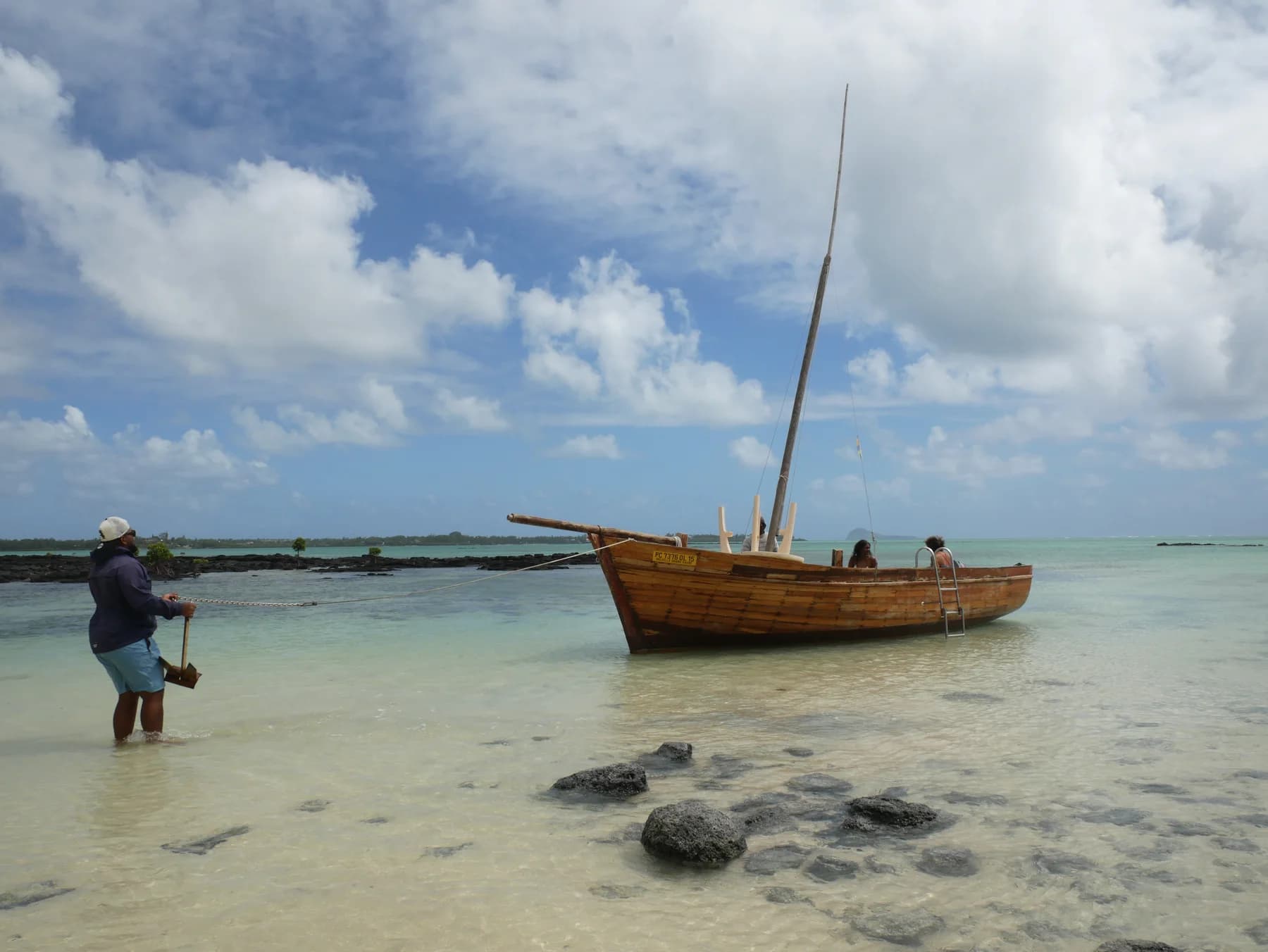 A wooden pirogue at anchor in shallow lagoon water