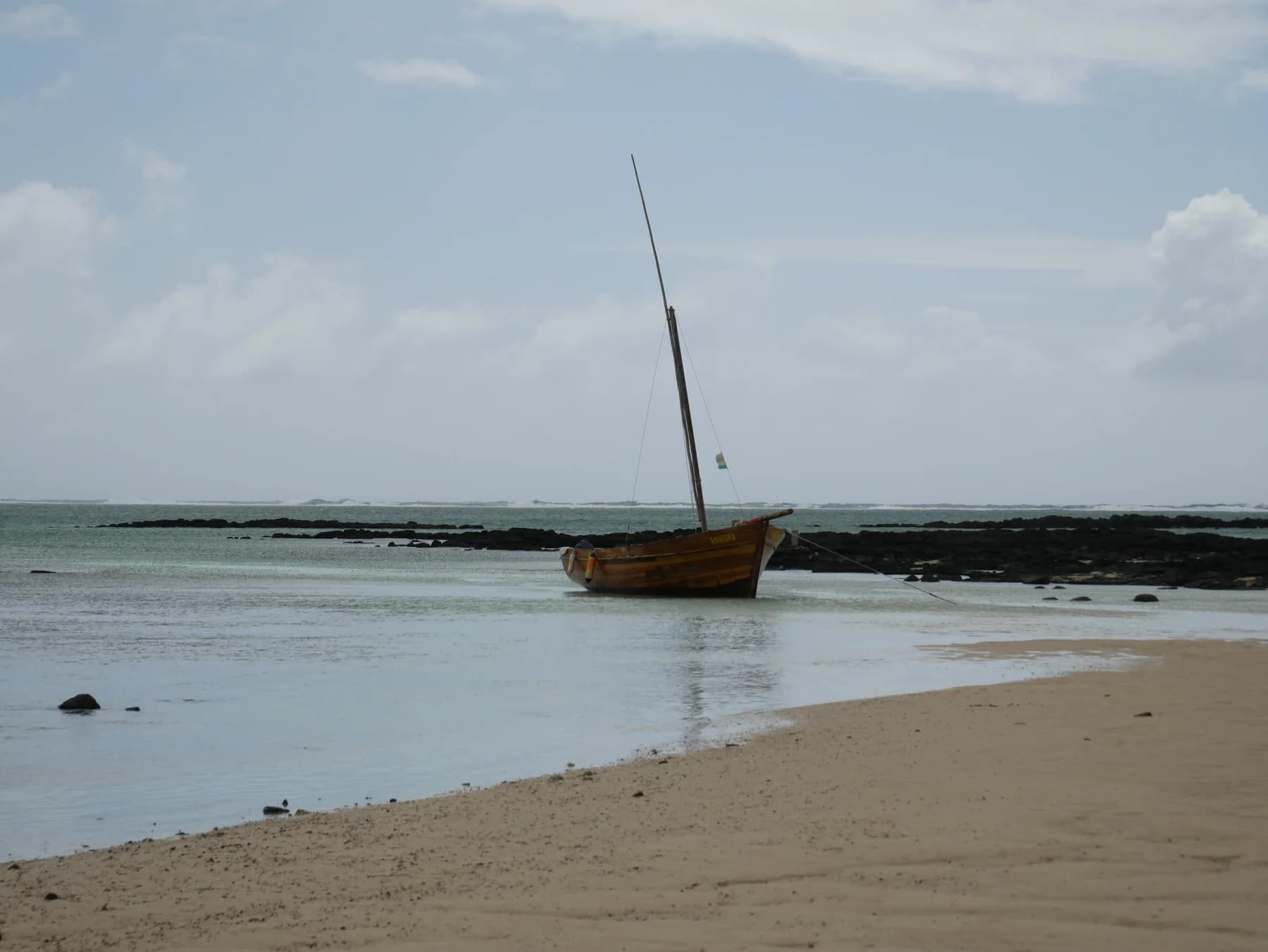 The wooden pirogue moored beside the beach