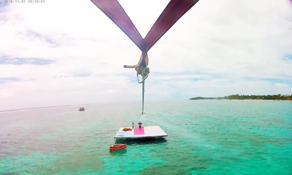 A colourful parasailing canopy flying above Belle Mare Lagoon