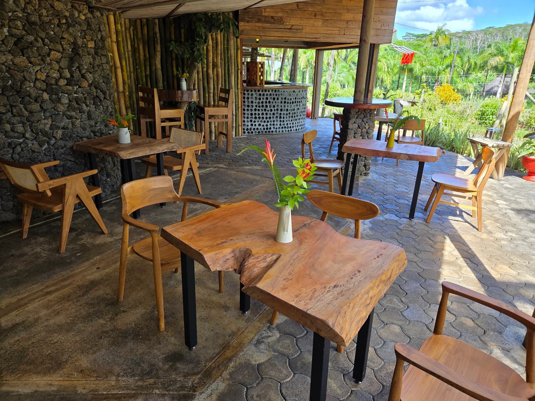The open terrace and wooden tables at Enbalao in Chamarel