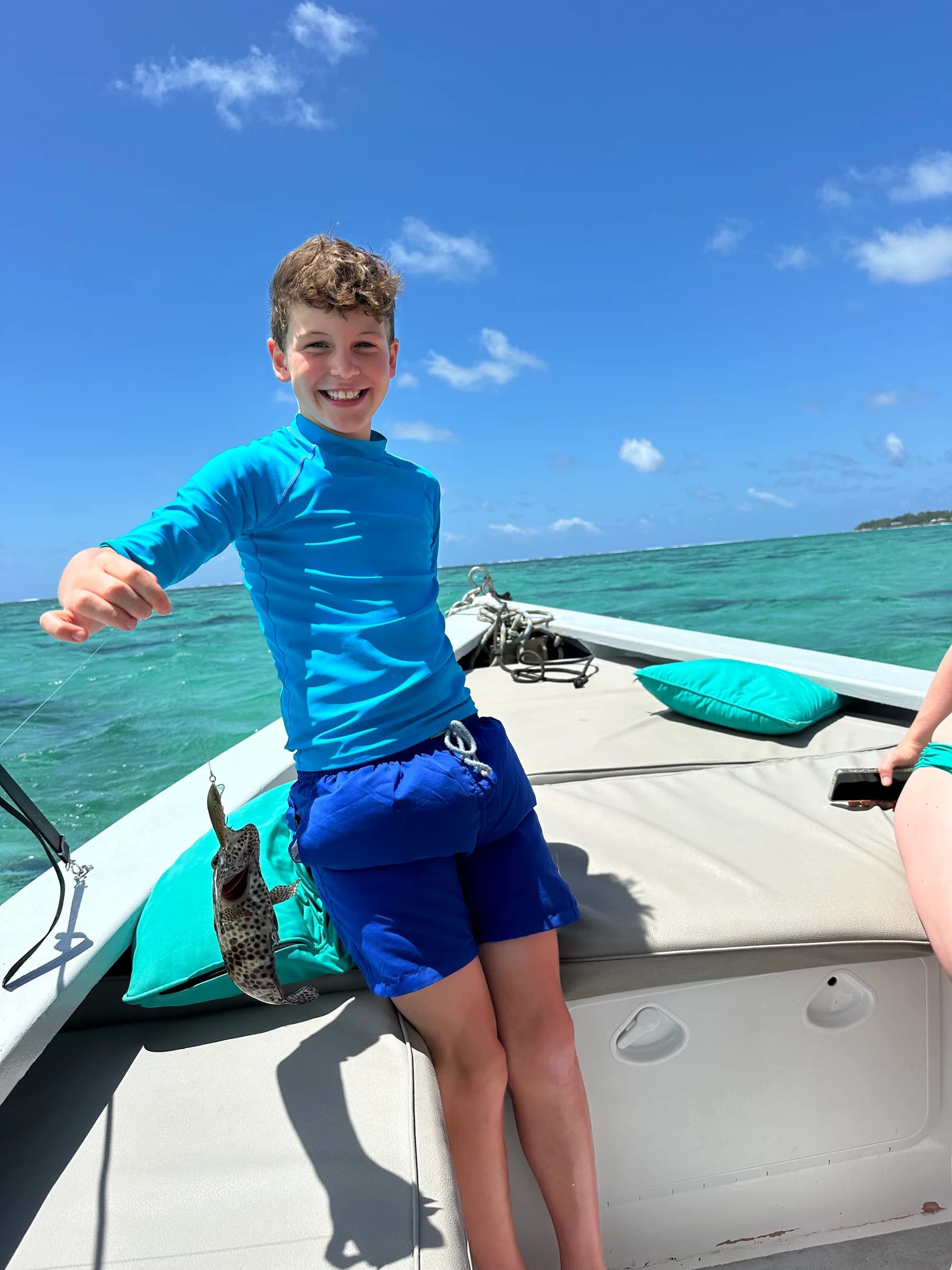 A young guest on board holding a fish