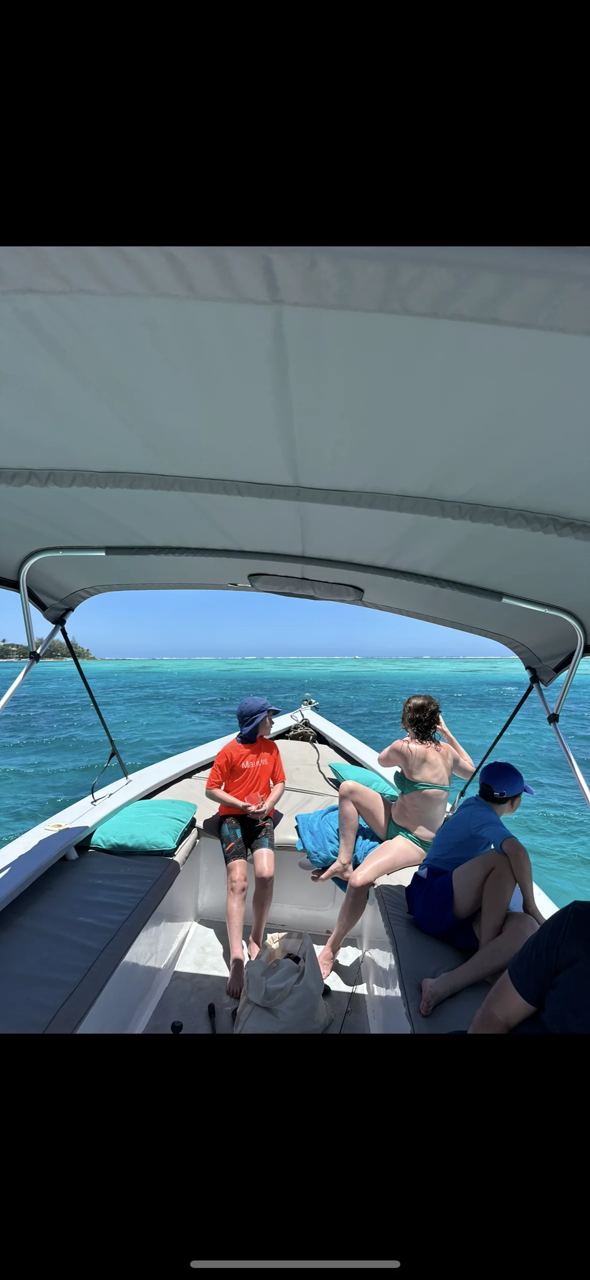 Gäste unter dem Sonnendach des Boots auf der Lagune