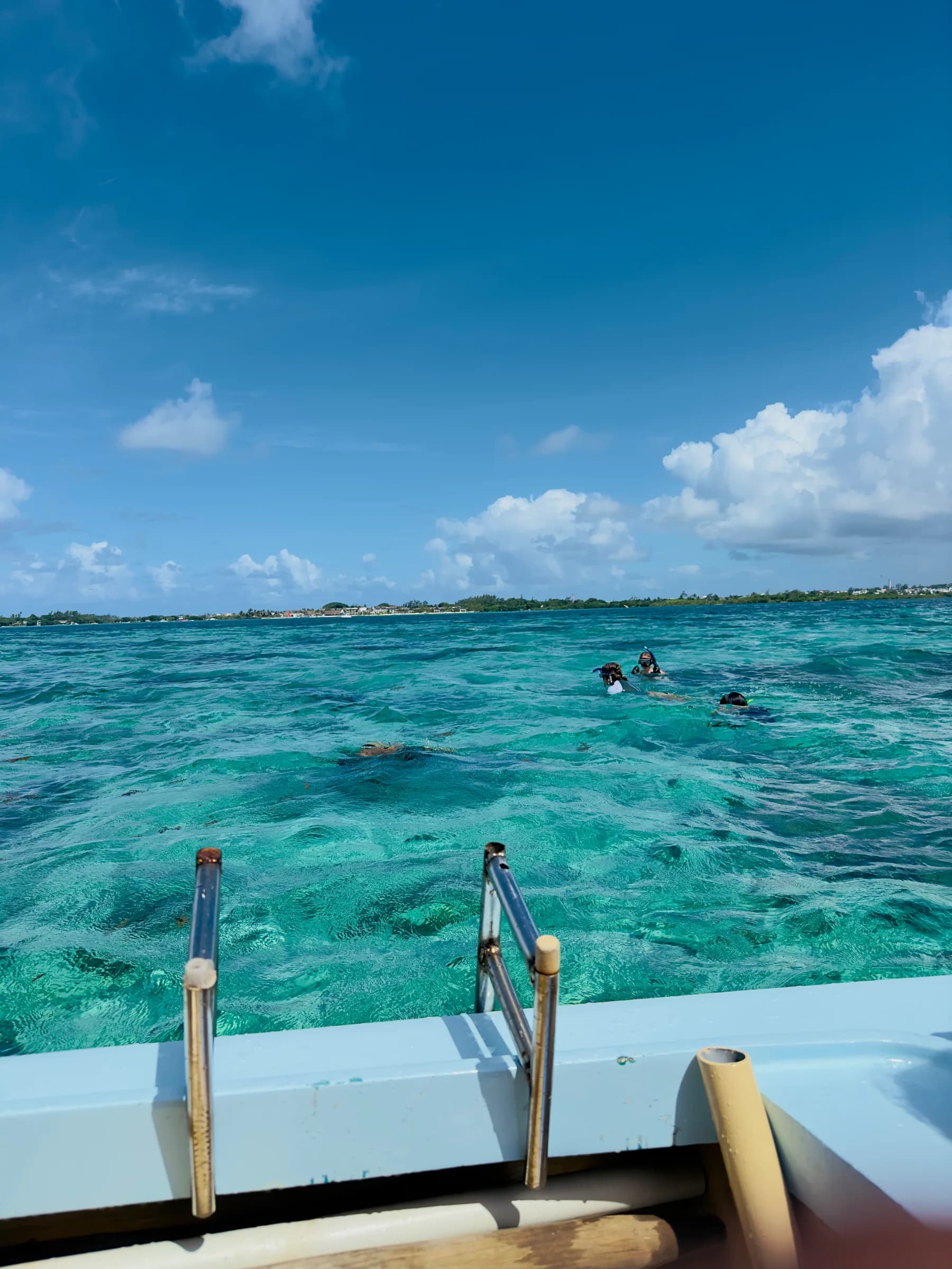 Snorkellers in clear turquoise water seen from the boat