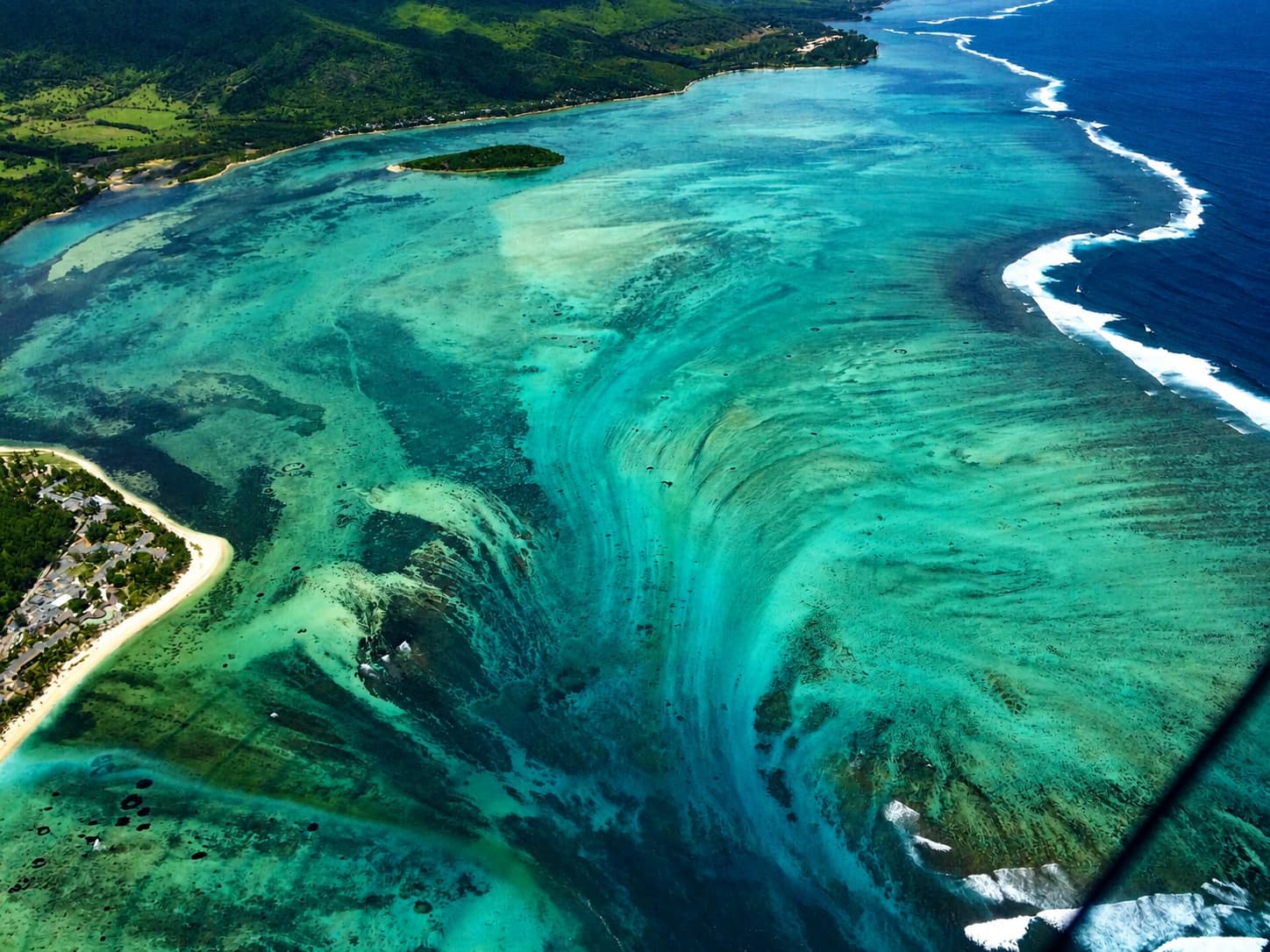 Aerial view of the underwater waterfall illusion beside the Le Morne peninsula