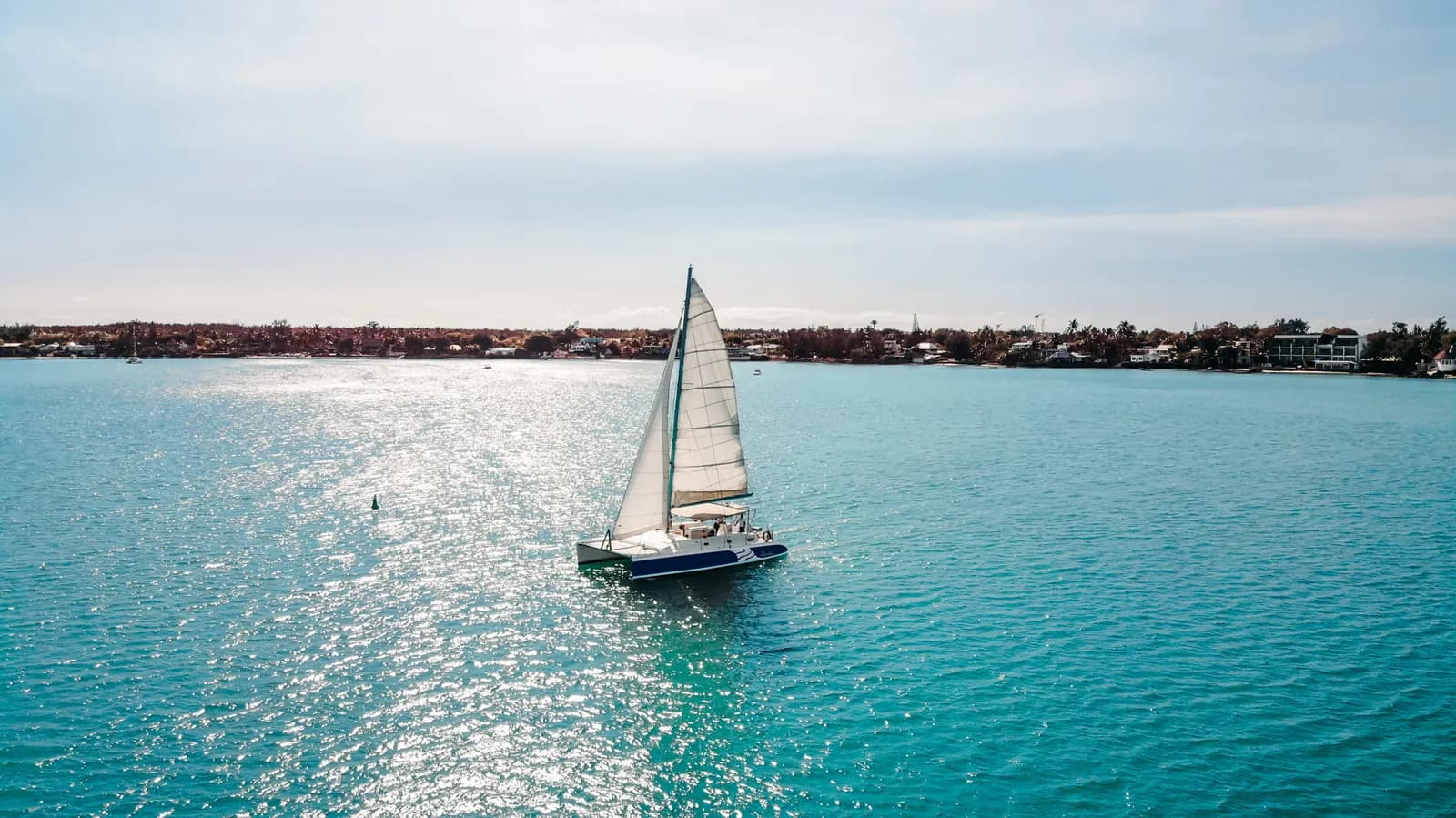 Un voilier traversant le lagon ensoleillé près de la côte