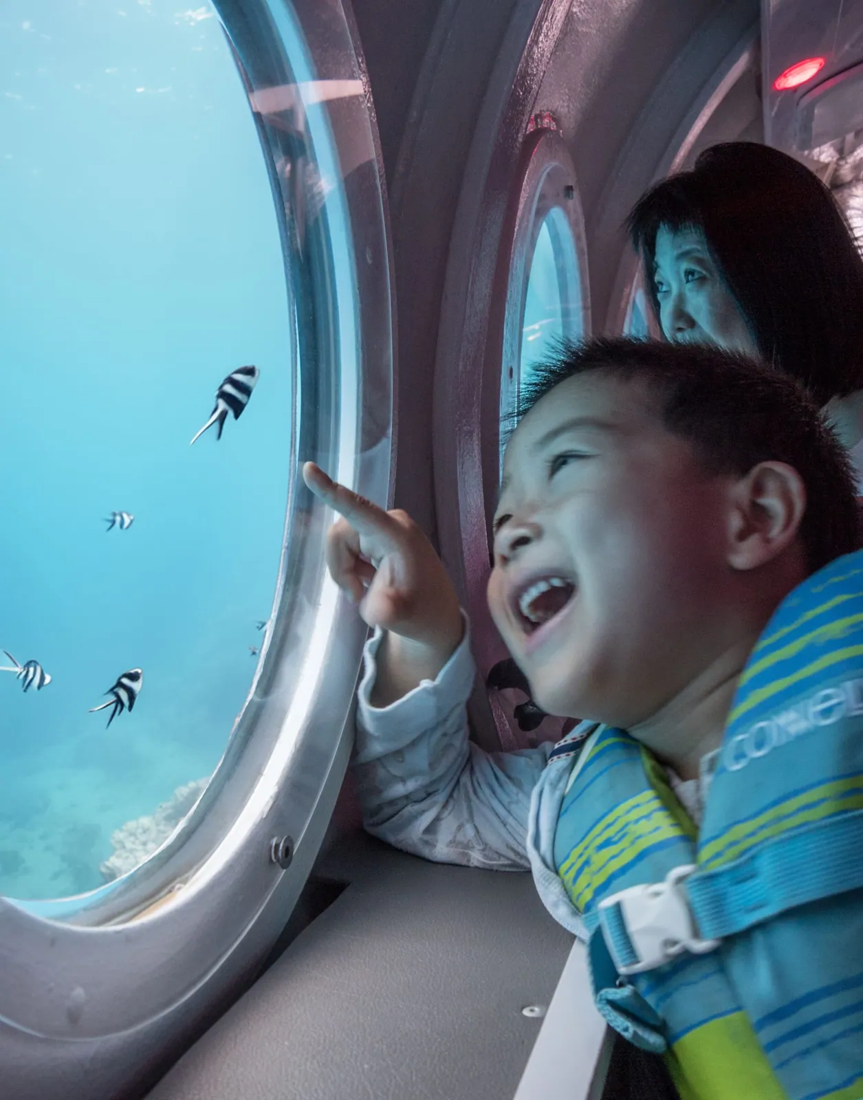 Un enfant regarde à travers le hublot d’observation d’un sous-marin