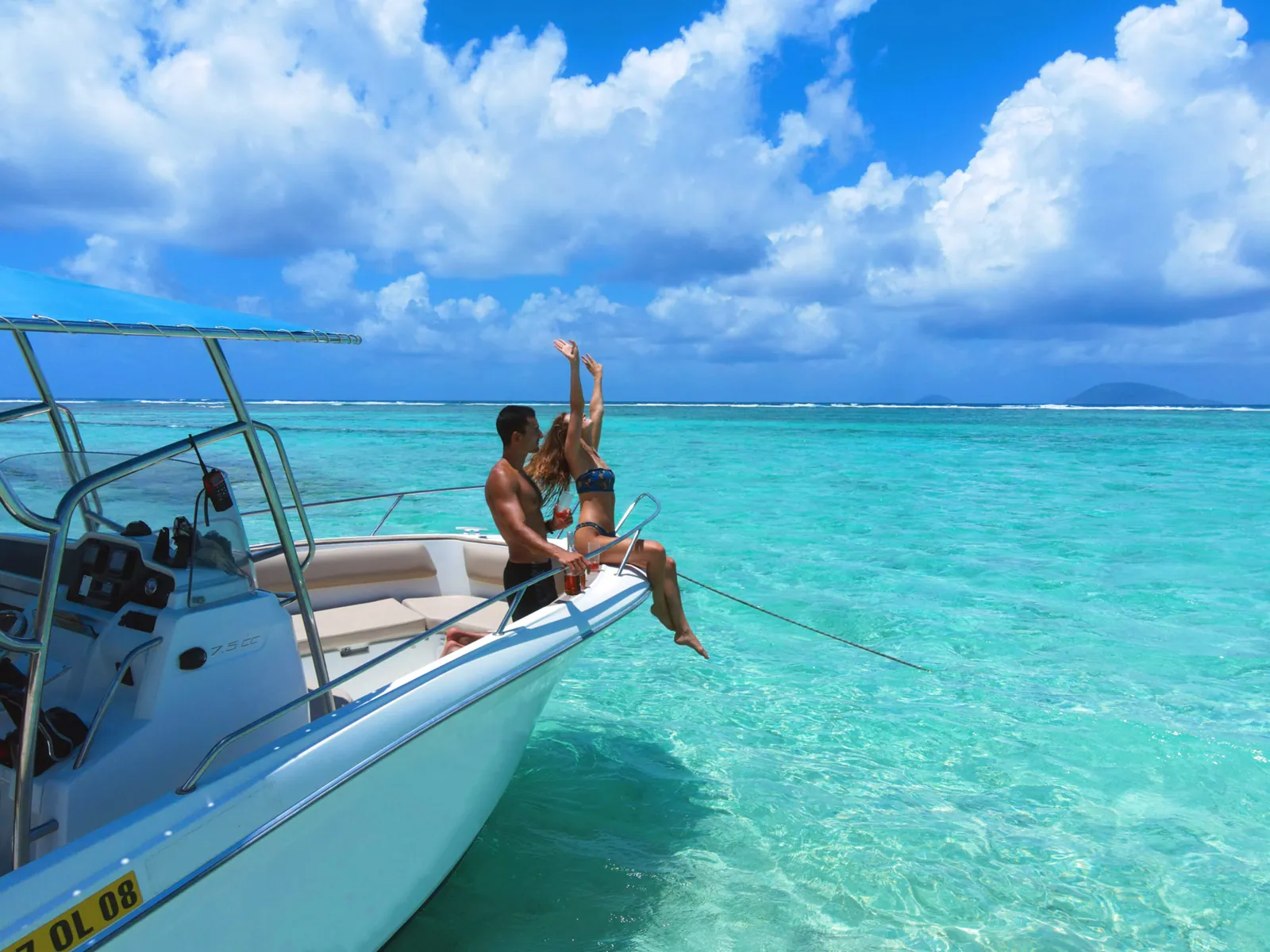 Des passagers assis à l’avant d’un bateau à moteur sur une eau turquoise