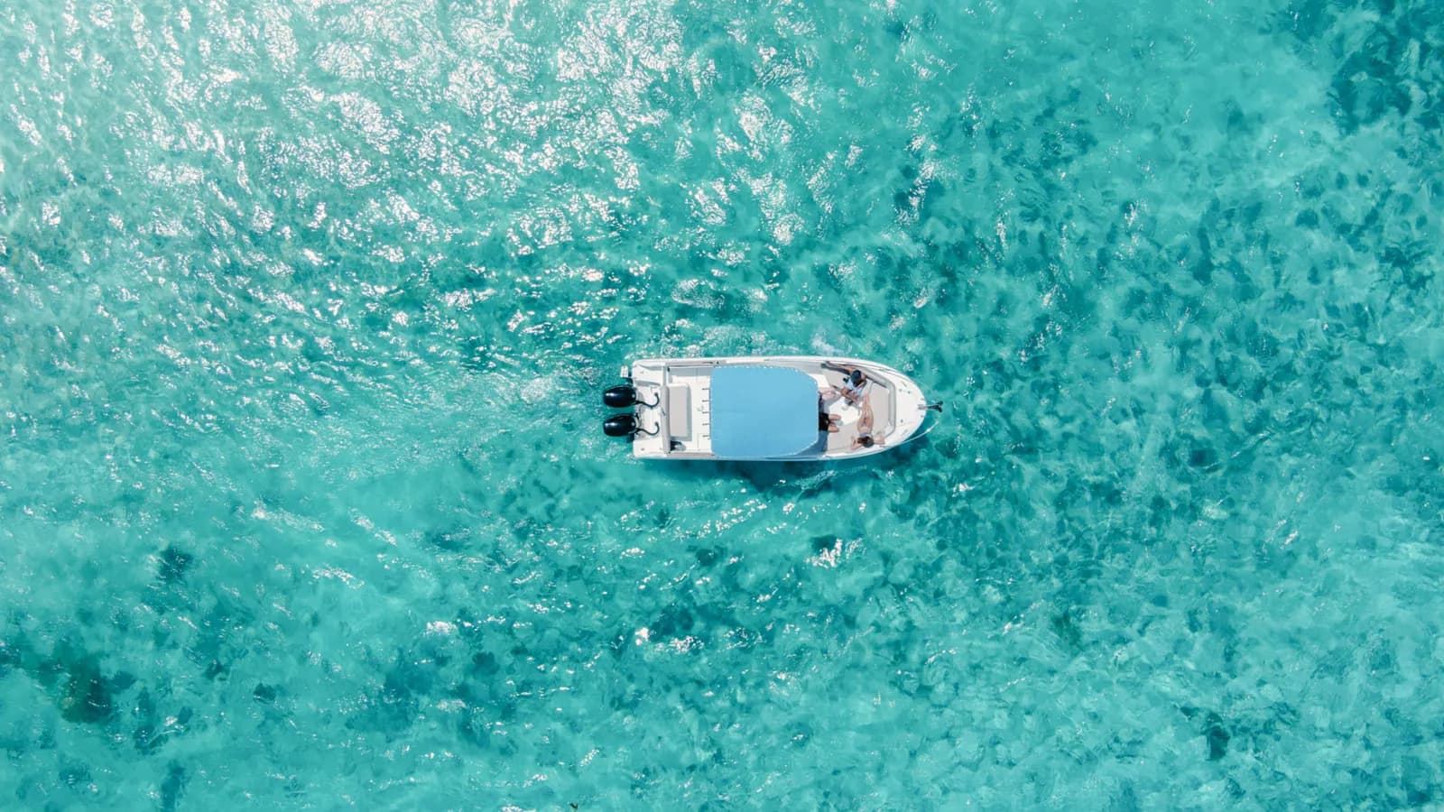 Overhead view of a speedboat on the turquoise lagoon