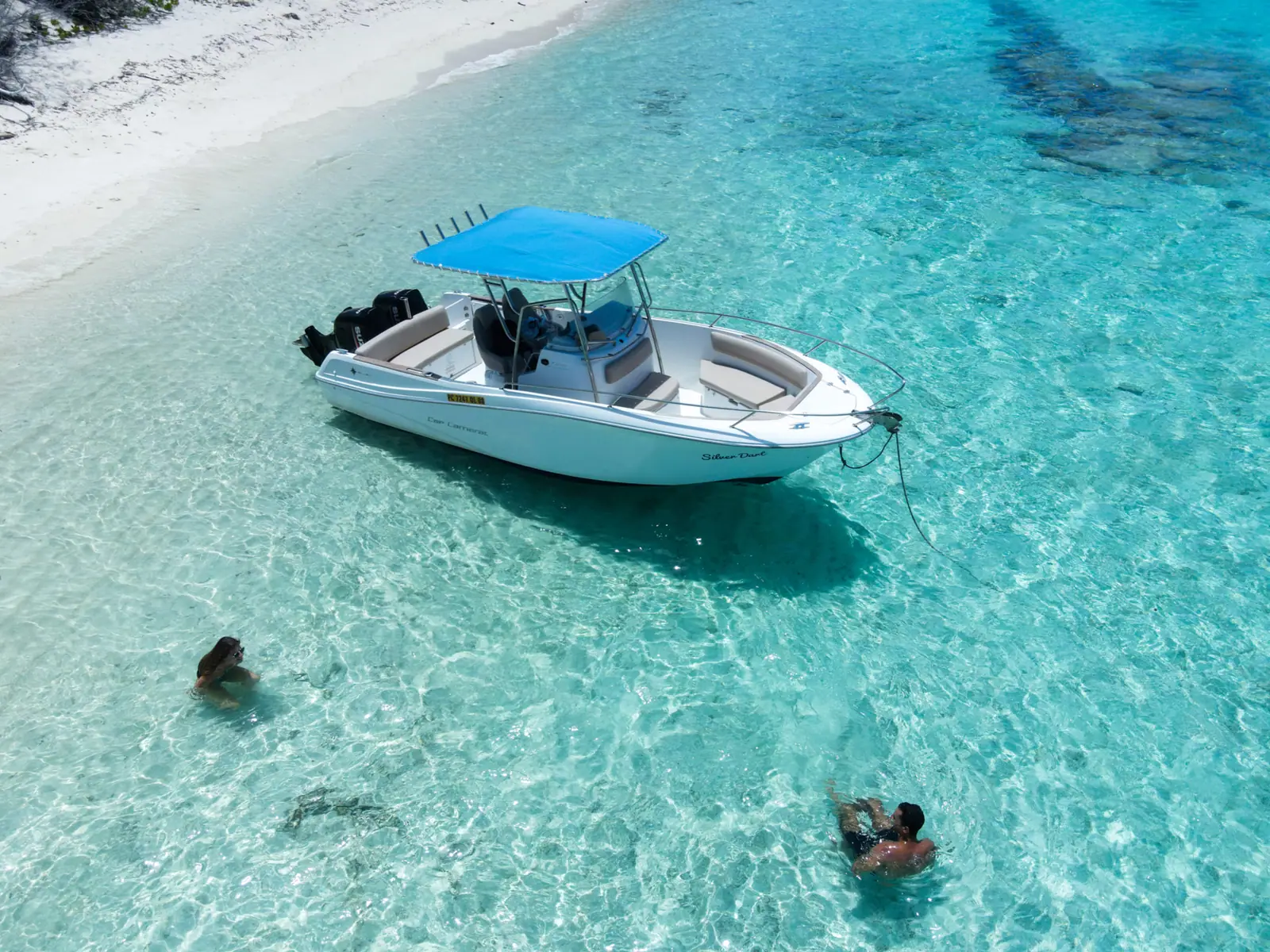 Guests swimming beside the anchored speedboat