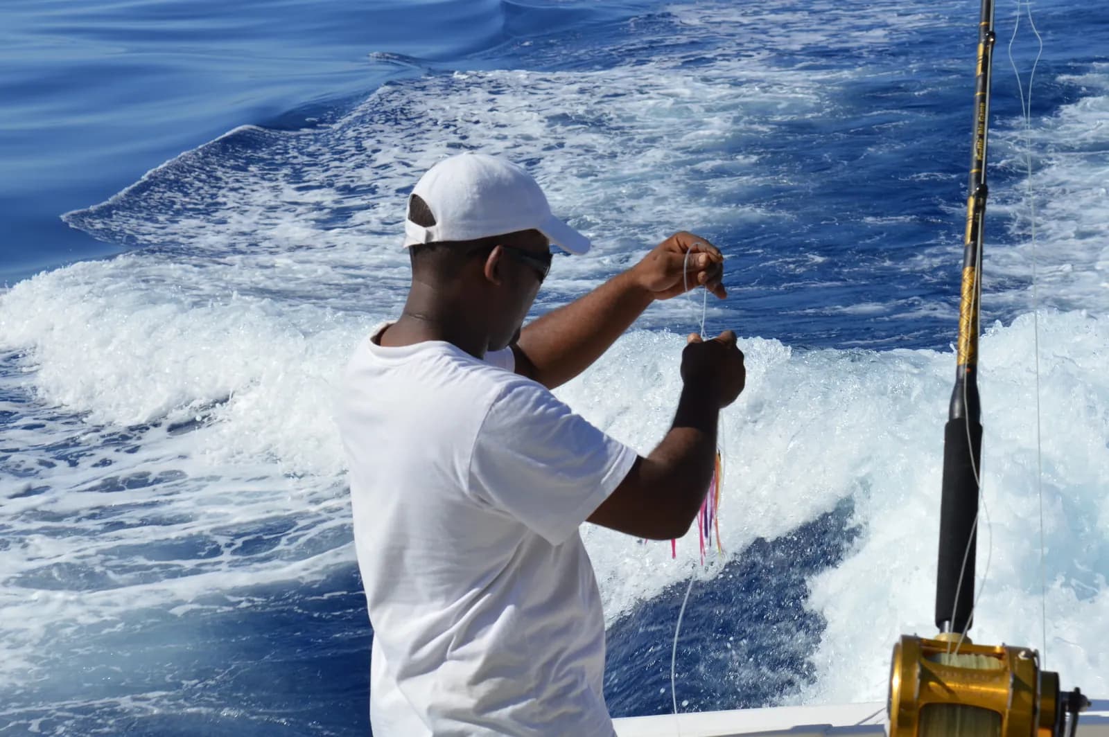 A crew member tending fishing lines at sea