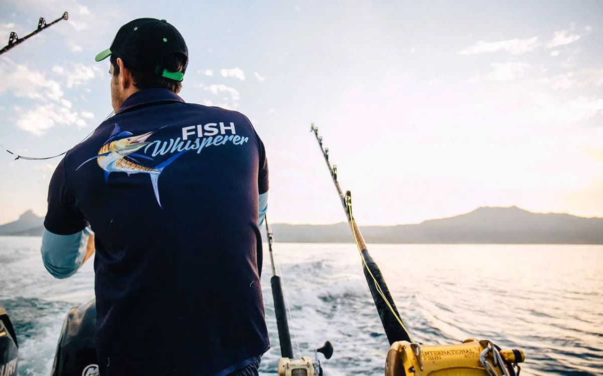An angler playing a fish from the stern of the boat