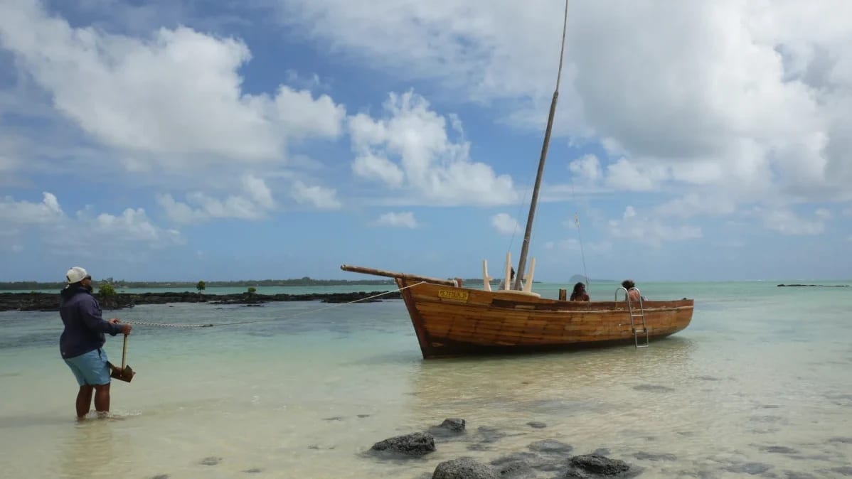 A wooden pirogue resting in shallow water near the shore