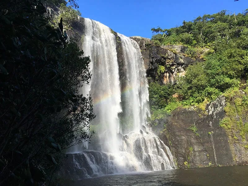 Hikers walking on uneven natural terrain at Tamarind Falls