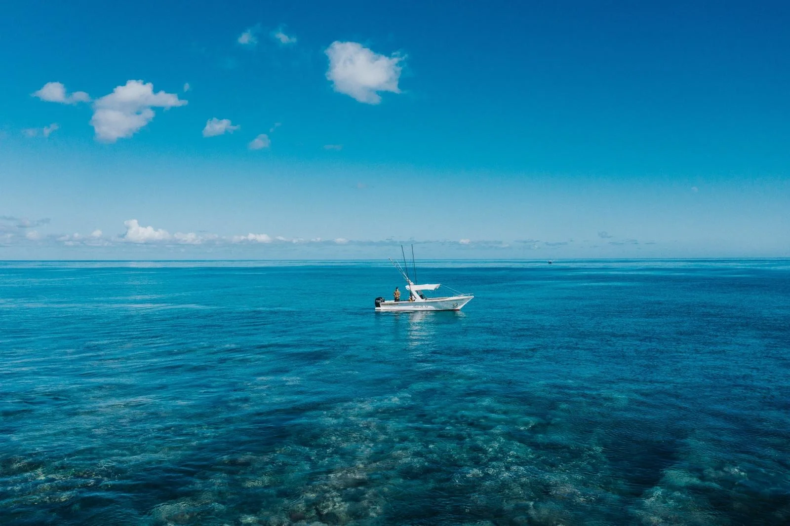 A covered motorboat anchored on clear lagoon water. Photograph from Pelagic Paradise Mauritius.