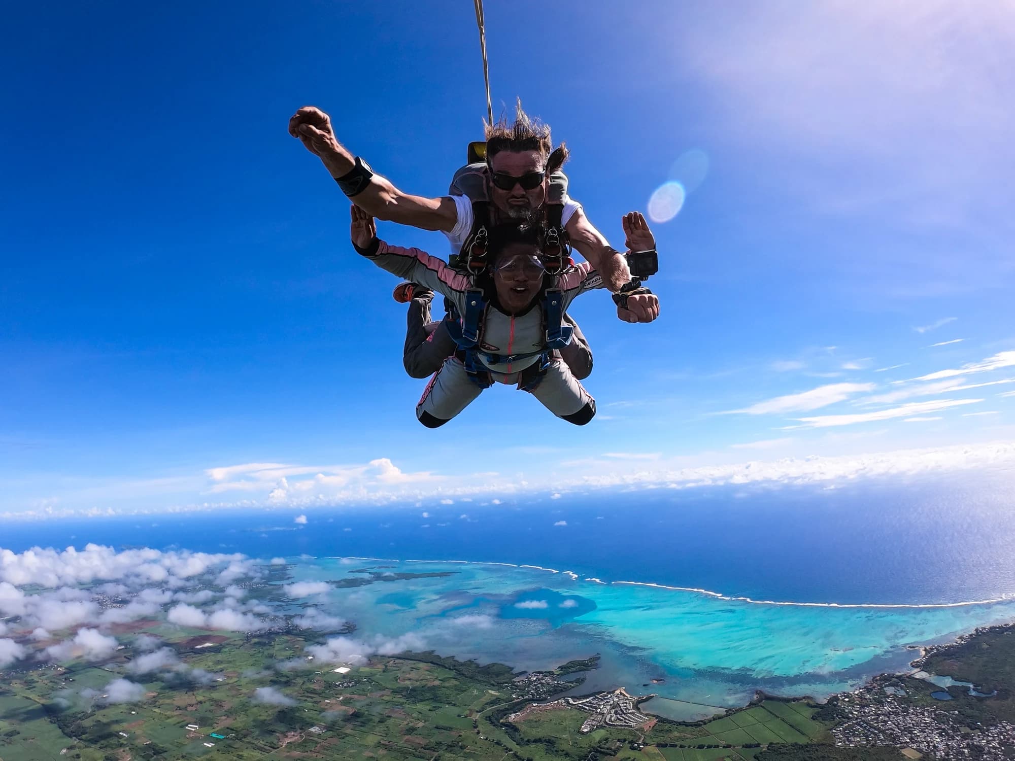 Ein Tandemspringer und sein Tandemlehrer im freien Fall über der Lagune von Mauritius