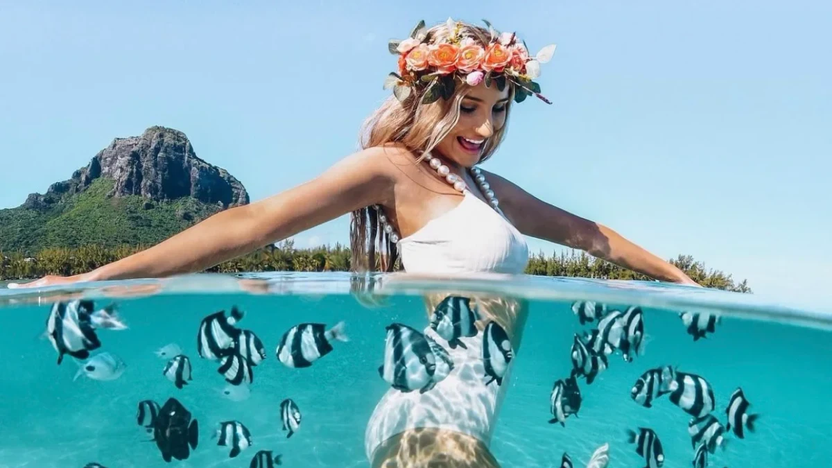 Un portrait à la surface avec une nageuse et des poissons sous l’eau