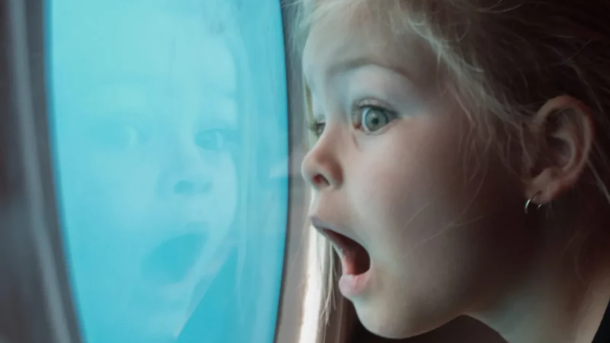 A child looking through a submarine cabin window