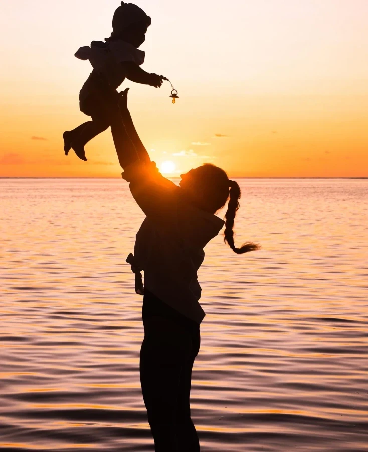 Silhouettes d’un adulte et d’un enfant dans la lumière du soir