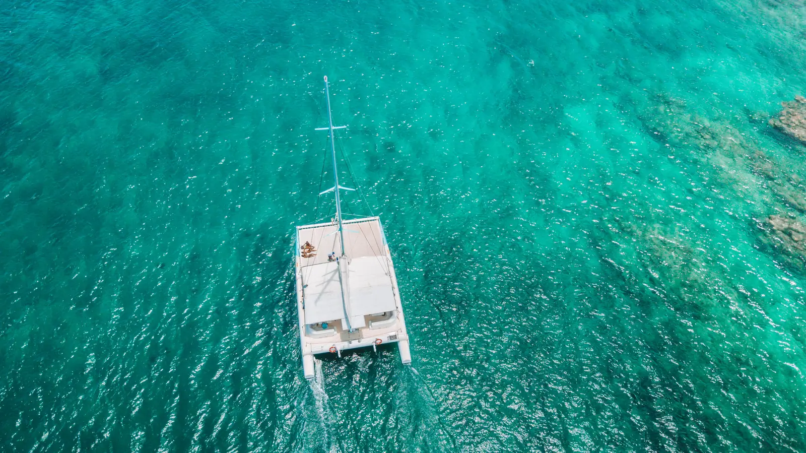 Vue aérienne d’un catamaran sur les eaux turquoise du lagon
